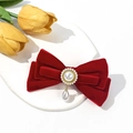 Close-up of red velvet bow hair clip with vintage pearls and elegant golden details - Red