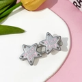 Gros plan de barrettes étoile avec texte Nice Day rose et petits strass sur plateau - Pince Étoile Double Strass (11#)