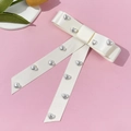 Elegant white silk long tail bow hair clip with silver heart beads on pink background - Beige