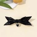 Détail d'une pince à cheveux avec nœud en satin noir et pendentif coeur scintillant - Noir