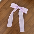 Detail view of a lavender mesh bow hair clip with scalloped edges on dark wood background - Purple