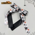 Dettaglio del fermaglio per capelli Halloween con motivi di zucca e gatto su nastro - Bianco