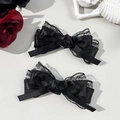 Detailed close-up of Gothic black lace hair clips with satin roses and ribbon bows - Black