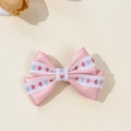 Dettaglio di fermaglio per capelli con fiocco in raso rosa e pizzo con cuori ricamati - Rosa