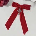 Detail van rode fluwelen strik haarclip met zilveren kruis en robijn edelsteen - Rood