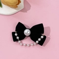 Detail of black velvet bow hair clip with a large center pearl and elegant hanging chain - Black