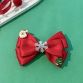 Makroaufnahme einer roten Weihnachtsschleife mit Weihnachtsmann und Schneeflocken-Dekor - Rot