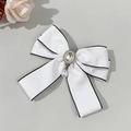 Dettaglio fiocco in jacquard bianco con strass centrale e pendente in perla a goccia - Bianco