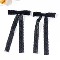 Detail von eleganten schwarzen Spitzen-Haarspangen mit langen Bändern auf Weiß - Ein Paar / Schwarz