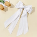 Detailed shot of large white satin bow hair clip with wavy lace trim and long ribbons - White