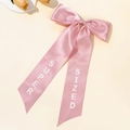 Elegant pink satin bow hair clip with long ribbons featuring Super Sized white letters - Pink
