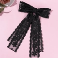 Detalle de elegante horquilla de encaje negro con lazo y cintas largas ornamentales - Negro