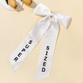 Detail of white satin bow hair clip with long ribbons and black SUPER SIZED print - White
