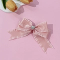 Dettaglio del fermaglio per capelli in raso rosa con strass a cuore e bordi con volant fini - Rosa