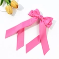 Close-up of bright pink satin bow hairpin with long ribbons and delicate scalloped edges - Rose Red