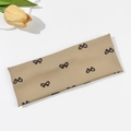Detail of khaki ribbed knit headband with bow pattern on cream fabric background - Khaki