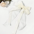 Detailed macro of cream velvet and organza layers on an elegant bow hair clip - Beige