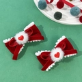 Dettaglio di fermagli per capelli in velluto rosso con pompon bianchi e cuore per stile festivo - Stile 3