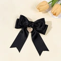 Close-up of elegant black satin bow hair clip featuring a gold heart-shaped metal pendant - Black