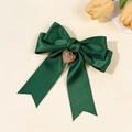 Nahaufnahme der dunkelgrünen Satin-Schleife Haarklammer mit goldenem Herzanhänger Detail - Dunkelgrün