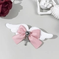 Dettaglio del fermaglio Goth Lolita con ali bianche, fiocco rosa e ciondolo a croce - Rosa