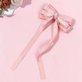 Detail van de roze satijnen haarstrik met linten en een gladde stoffen textuur - Roze