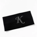 Detail of black ribbed knit sports headband featuring a sparkling rhinestone letter K - Letter K Style