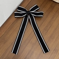 Dettaglio di fiocco in gros-grain nero con cuciture bianche a contrasto su legno - Molletta Fiocco con Nastrini Lunghi Nero (7#)