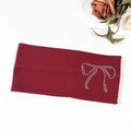 Close-up of a burgundy ribbed knit headband featuring a sparkling rhinestone bow detail - Burgundy