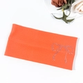 Macro shot of bright orange ribbed knit headband with sparkling rhinestone bow accent - Orange