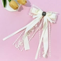 Detailaufnahme einer weißen Spitzen-Haarklammer mit Vintage-Edelstein und bronzenem Relief - Beige