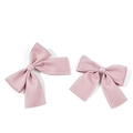 Dettaglio dei fermacelli a fiocco rosa con cuciture bianche su sfondo bianco pulito - Rosa (Stile 5)