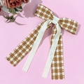 Detalle del lazo elegante de pata de gallo con cinta crema sobre fondo rosa - Beige