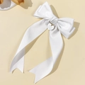 Detail einer weißen Satin-Schleifen-Haarklammer mit graviertem Herz-Anhänger - Weiß