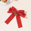 Detail von roter Seidenschleife Haarspange mit goldenem Herzanhänger auf beigem Grund - Rot