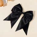 Close-up of a large black satin bow hair clip with elegant silk texture on a beige background - Black