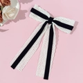 Close-up of elegant white lace and black velvet ribbon hair clip on pink background - Black