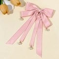 Dettaglio del fermaglio per capelli con fiocco di raso rosa e perle pendenti - Rosa