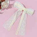 Detail of white lace hair clip with velvet bow and long elegant streamers on pink background - Beige