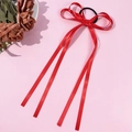 Dettaglio di elastico per capelli con fiocco in raso rosso e lunghi nastri su sfondo rosa - Rosso