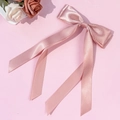 Elegante lazo de satén rosa con lunares y cintas largas sobre un fondo floral suave - Rosa