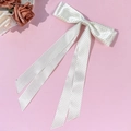 Detalle de un lazo de satén blanco con lunares negros y cintas largas elegantes - Beige