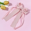 Nœud rose à texture gaufrée et rubans de satin sur fond doux avec des tulipes fraîches - Rose