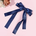 Close-up of navy blue polka dot bow hair clip with ribbons on pink surface - Navy Blue