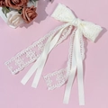 Detailansicht der eleganten weißen Spitzen-Haarklammer mit fließenden Satinbändern und Blumen - Beige