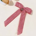 Detail of red plaid bow hair clip with a rhinestone cherry charm on cream background - Red