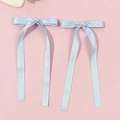 Paire de barrettes à nœuds en satin bleu clair avec perles sur fond rose pastel - Bleu