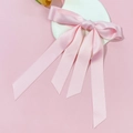 Detail von rosa Satin-Schleifen-Haarspange mit langen Bändern auf weißem Herz - Rosa