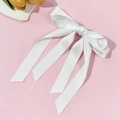 Detailansicht der glatten weißen Satinstruktur dieser eleganten mehrlagigen Schleifenspange - Weiß