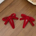 Pair of deep red velvet bow hair clips with elegant retro texture on a wooden surface - Red